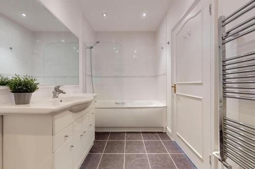 a bathroom with a sink and a tub and a shower at Prime Location Prince's Gate Mews 4BD 3 BATH in London