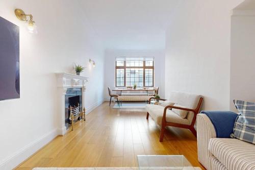 a living room with a couch and a fireplace at Prime Location Prince's Gate Mews 4BD 3 BATH in London