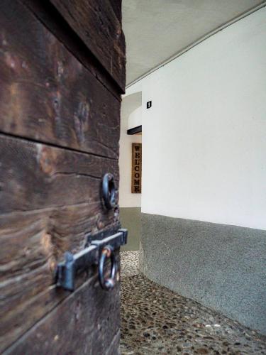 a wooden door with a metal handle on a wall at Casa Armida in Tirano