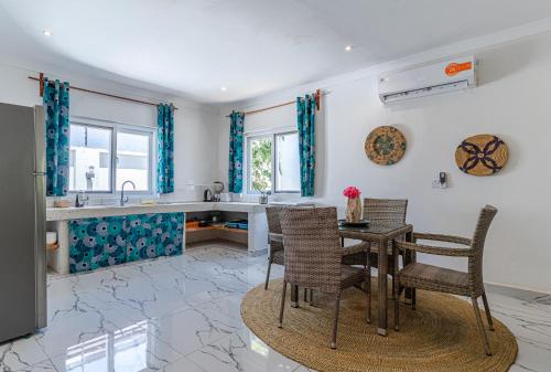a kitchen with a table and chairs and a counter at Jambiani Residence in Jambiani