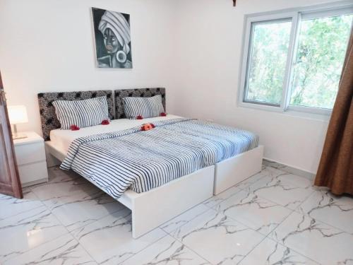 a white bedroom with a large bed and a window at Jambiani Residence in Jambiani