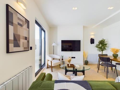 a living room with a green couch and a table at Be London - Maida Vale Residences in London