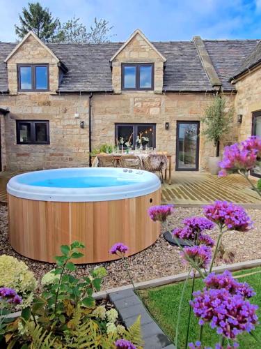 a garden with a hot tub in front of a house at Luxury Cottage in Peak District near Alton Towers in Stanton