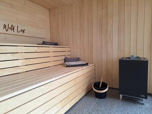 a sauna with a trash can and a bucket at Waldlux Luxus-Chalet Brennhus in Kappelrodeck