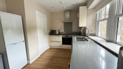 a kitchen with a white refrigerator and a sink at 19 Snowdon Apartment in Stirling