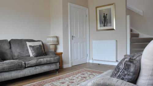 a living room with a couch and a staircase at 19 Snowdon Apartment in Stirling