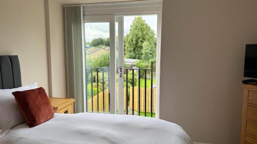 a bedroom with a bed and a sliding glass door at 19 Snowdon Apartment in Stirling