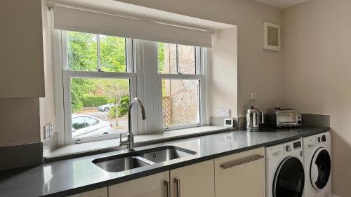 a kitchen with a sink and a washing machine at 19 Snowdon Apartment in Stirling