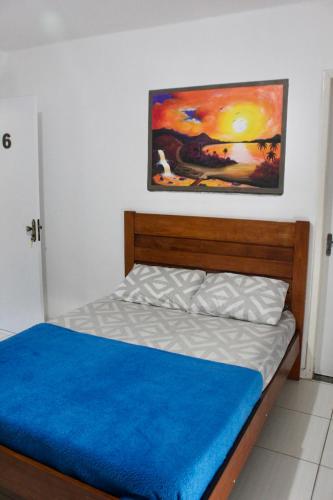 a bedroom with a bed with a painting on the wall at Aloha Pousada Cabo Frio Hospedagem Econômica in Cabo Frio
