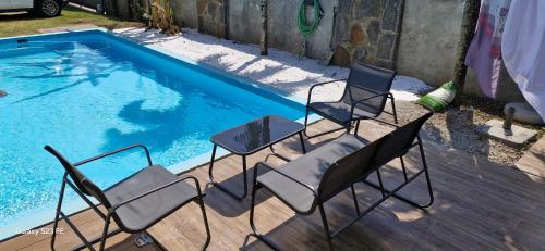 two chairs and a table next to a swimming pool at Appartement de luxe Grand Baie in Pereybere