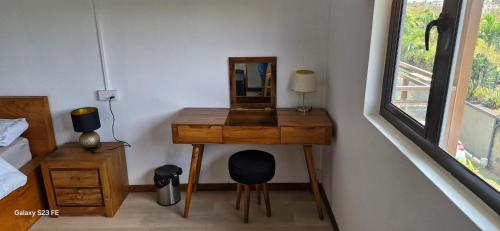 a bedroom with a wooden desk with a mirror at Appartement de luxe Grand Baie in Pereybere