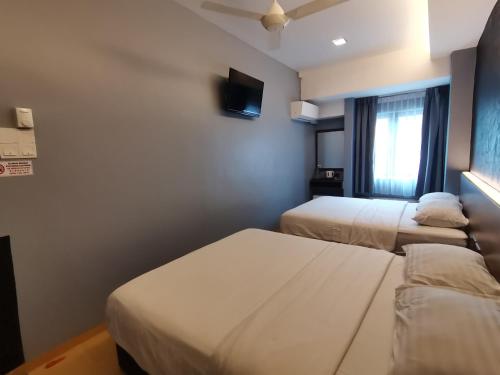 Una cama o camas en una habitación de Lumut Hotel