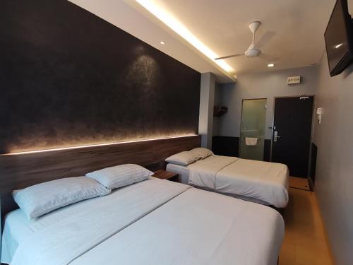 Una cama o camas en una habitación de Lumut Hotel