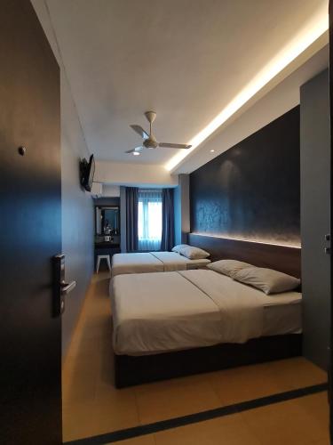 Una cama o camas en una habitación de Lumut Hotel
