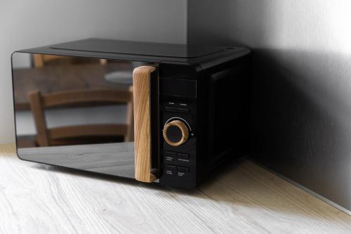 a black microwave oven with a wooden door at Apartmány Vilka Orlík in Teplice nad Metují