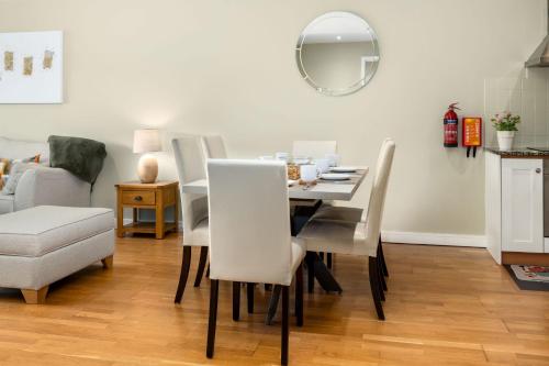 a dining room with a table and chairs and a mirror at Apartment 453 - Clifden in Clifden
