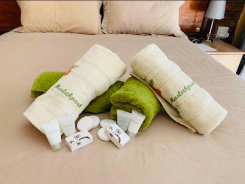 ein Bett mit zwei Handtuchrollen und zwei aufgerollten Handtüchern in der Unterkunft Umhlanga Kruger in Marloth Park
