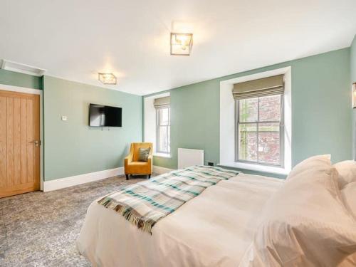 a bedroom with a large bed and a chair at Eye Mouth Luxury Stays in Eyemouth
