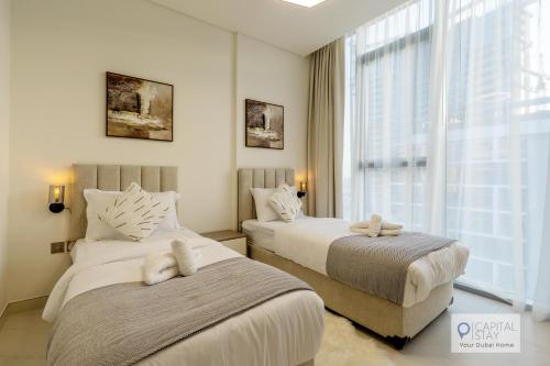 a bedroom with two beds and a large window at 2 Bed Apt in District One Dubai - Lagoon Views in Dubai