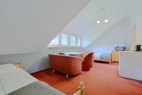 a bedroom with two chairs and a table in a room at Willa Marion in Karpacz