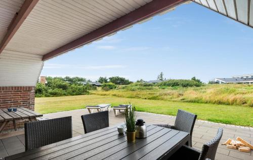 a wooden table and chairs on a patio at Holiday Home Fladsbjergvej Iii in Klegod