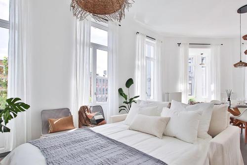 a white bedroom with a large white bed with white pillows at La bulle bohème - Entièrement neuf, près de Spa in Verviers