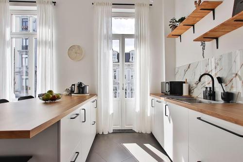 a white kitchen with white cabinets and a sink at La bulle bohème - Entièrement neuf, près de Spa in Verviers