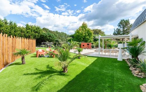 a backyard with a lawn with palm trees at Modern Villa With Private Pool in Saint-Aignan-Grand-Lieu
