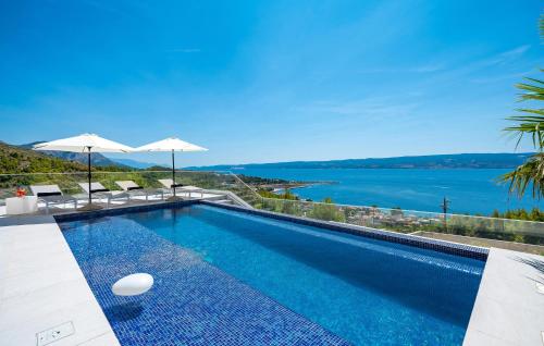 a swimming pool with a view of the ocean at 3 Bedroom Lovely Home In Dugi Rat in Dugi Rat