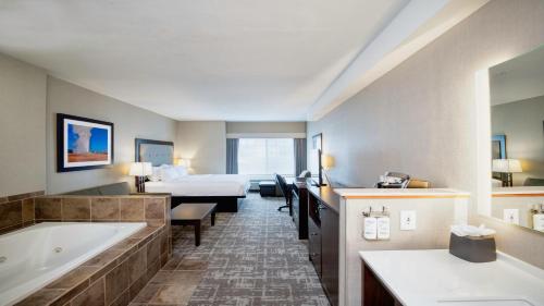 a hotel room with a tub and a bed at Holiday Inn West Yellowstone by IHG in West Yellowstone