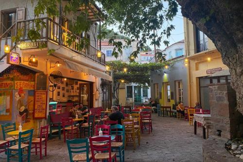 a group of people sitting at an outdoor restaurant at The Bridge House Plomari in Plomarion