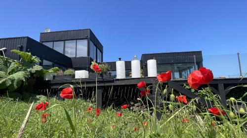 une maison avec des fleurs rouges devant elle dans l'établissement La résidence de la Villa Quartz, à Varengeville-sur-Mer