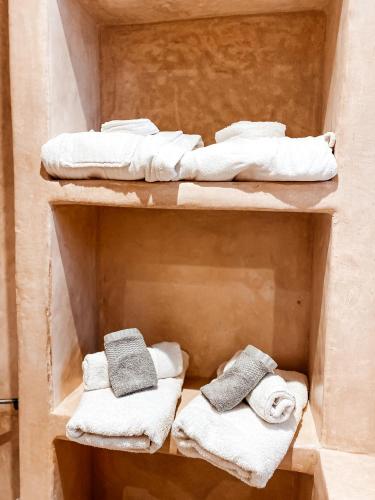 two shelves with towels and towels in a room at Riad Al Manara in Essaouira