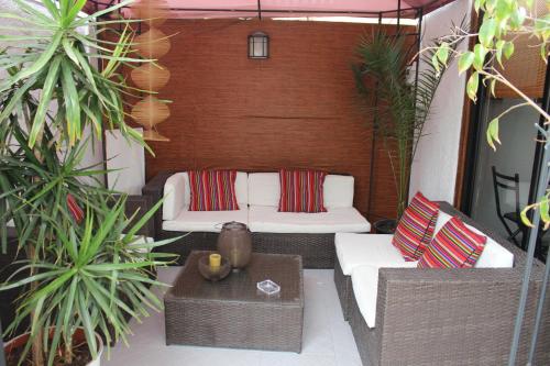 a patio with white couches and a table and plants at Hotel Velero Sur in Iquique