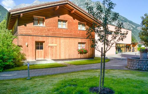 a wooden house with a tree in front of it at Tolles Feriehaus Montafon in Bartholomäberg