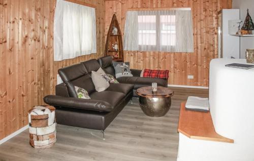 a living room with a leather couch and a table at Tolles Feriehaus Montafon in Bartholomäberg