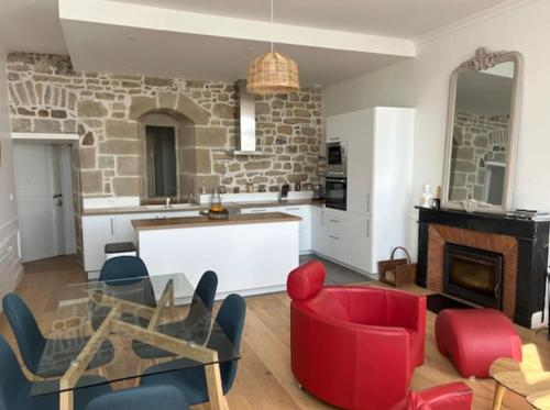 - un salon avec une table en verre et des chaises rouges dans l'établissement Appartement de standing Face Mer, au Croisic