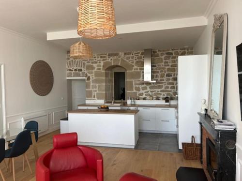 une cuisine avec une chaise rouge et un mur en briques dans l'établissement Appartement de standing Face Mer, au Croisic
