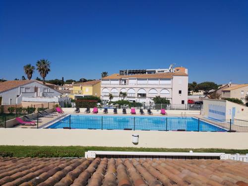 une grande piscine devant un immeuble dans l'établissement Studio Mezzanine Lips Village Naturiste, au Cap d'Agde