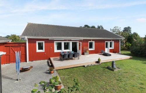 ein rotes Haus mit einer Terrasse in der Unterkunft 3 Bedroom Awesome Home In Glesborg in Glesborg