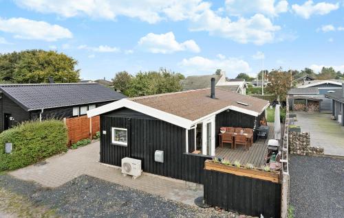 a black house with a white roof and a patio at Cozy Home In Otterup With Wifi in Otterup