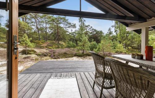 eine Holzterrasse mit 2 Stühlen und einem Tisch in der Unterkunft 2 Bedroom Nice Home In Nexø in Vester Sømarken