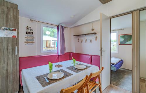 a dining room with a table and a pink couch at Stunning Stacaravan in Saint-Georges-de-Didonne