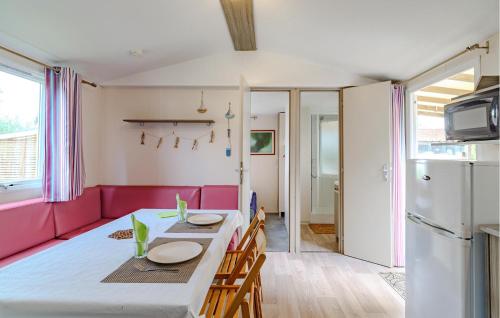 a kitchen and dining room with a table and pink couch at Stunning Stacaravan in Saint-Georges-de-Didonne