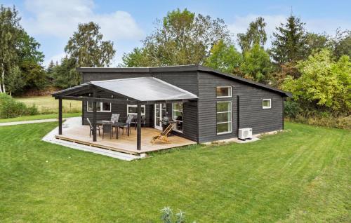 a black tiny house with a deck and a table at Cozy Home In Bogø By With Wifi in Bogø By