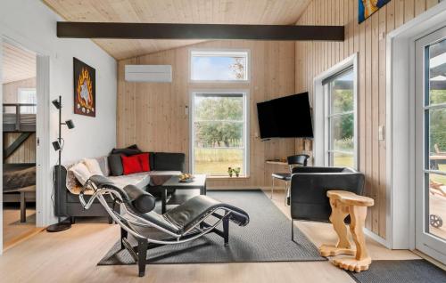a living room with a couch and chairs and a tv at Cozy Home In Bogø By With Wifi in Bogø By