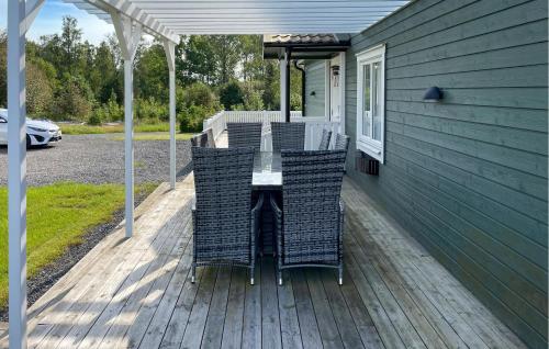 a deck with chairs and a table on a house at Cozy Home In Dörarp With Sauna in Dörarp