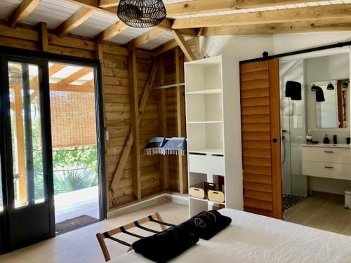 a bedroom with a bed and a large window at Vivez cet instant in Le Gosier