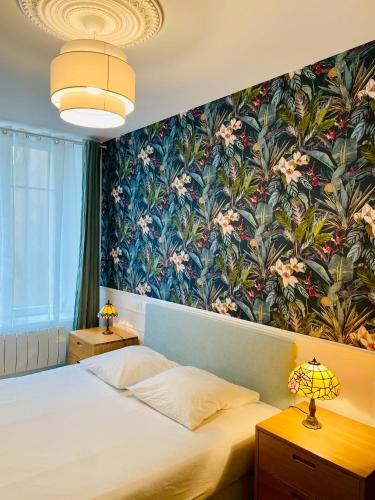 - une chambre avec un grand lit et du papier peint floral dans l'établissement La bulle Stanislas, à Nancy