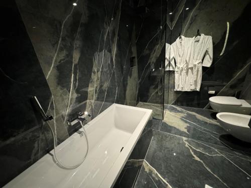 a bathroom with a tub and a sink and a toilet at Arka Art Hotel in Tirana